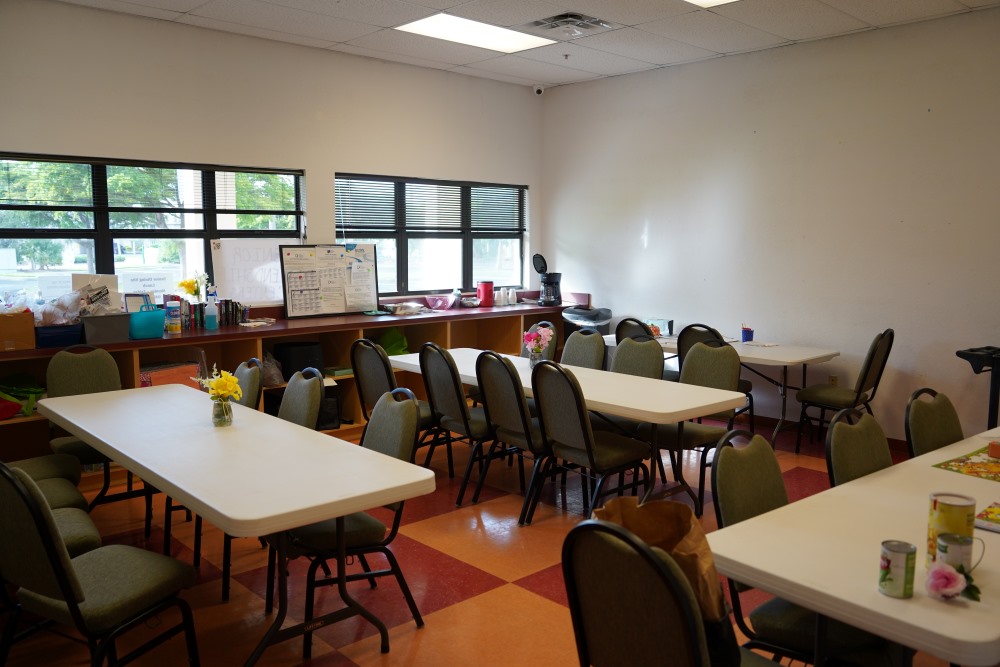 Meeting room with round tables and chairs arranged on a red-and-tan tiled floor
